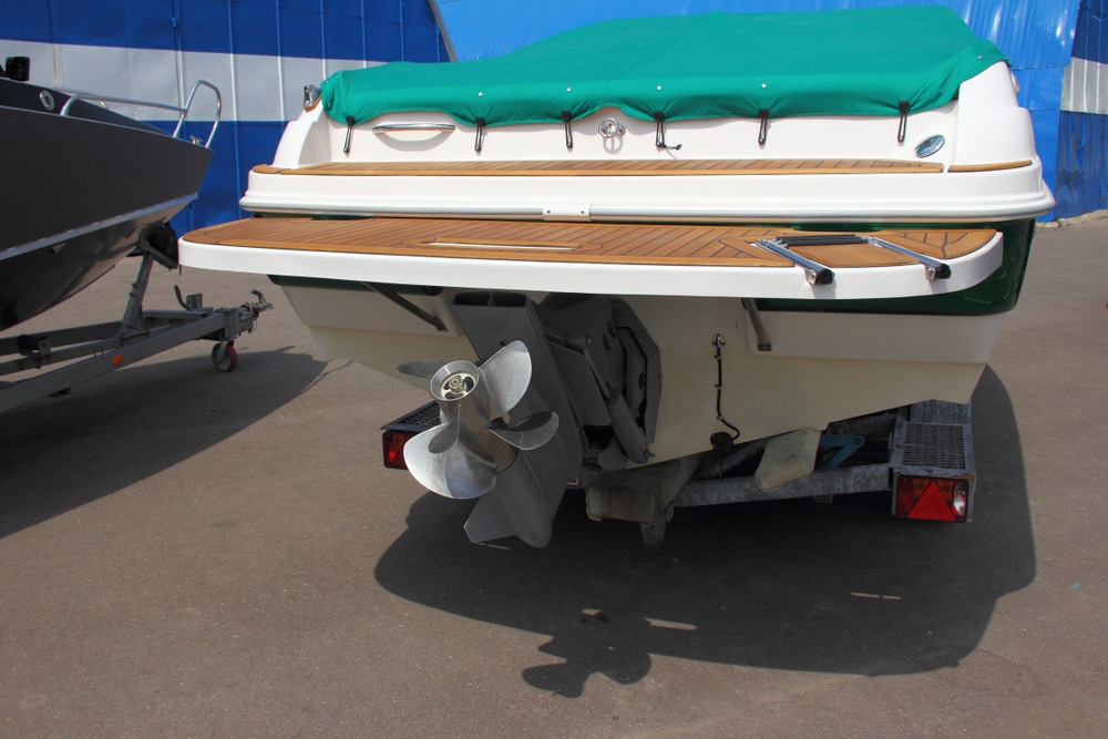 White Boat Transom With A Green Awning On The Shore