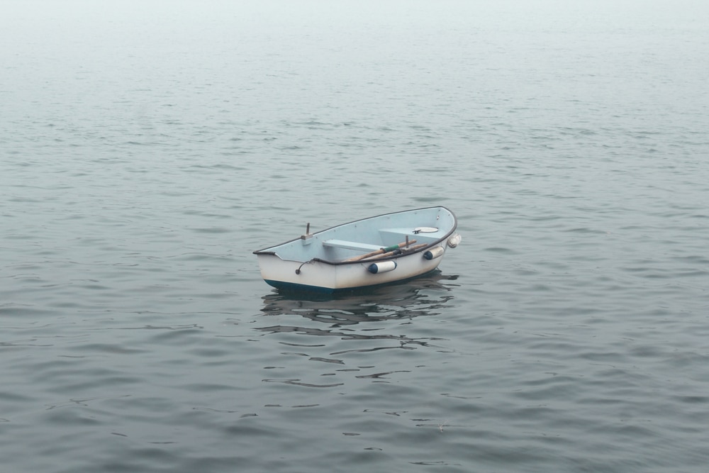 a small drift boat in the middle of sea