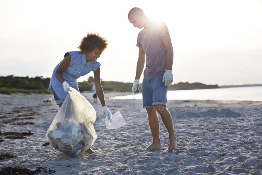 a couple picking trsh from the sea side