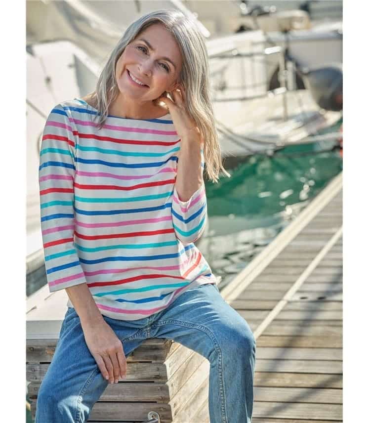 a lady is wearing stripped shirt with pent sitting at the sea port