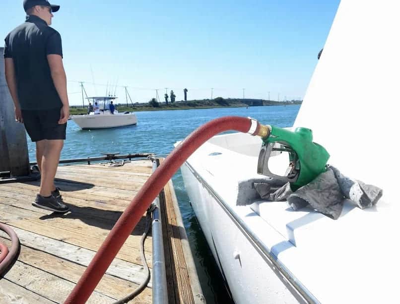 a man standing along with the boat and fueling the boat