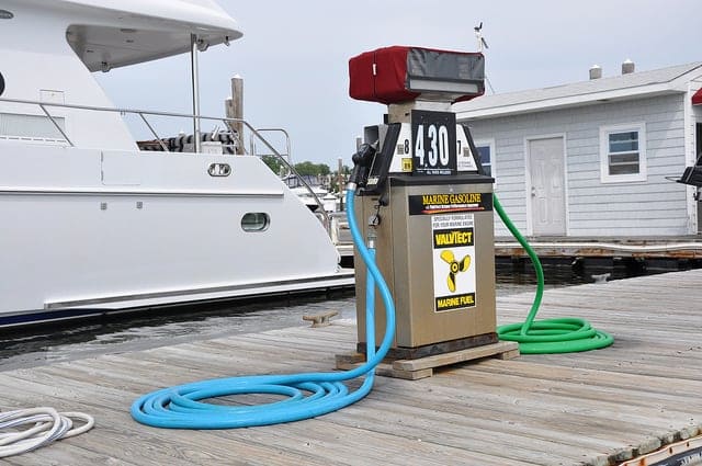 a white color boat at the port along with the boat fuel dispenser