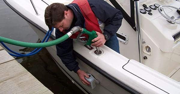 man is checking a fuel tank after fueling the boat