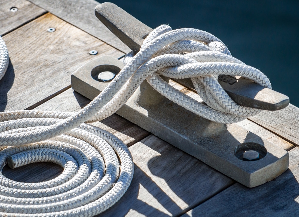 A cleat hitch and neatly rounded rope sit on a dock alongside the Intracoastal Waterway.