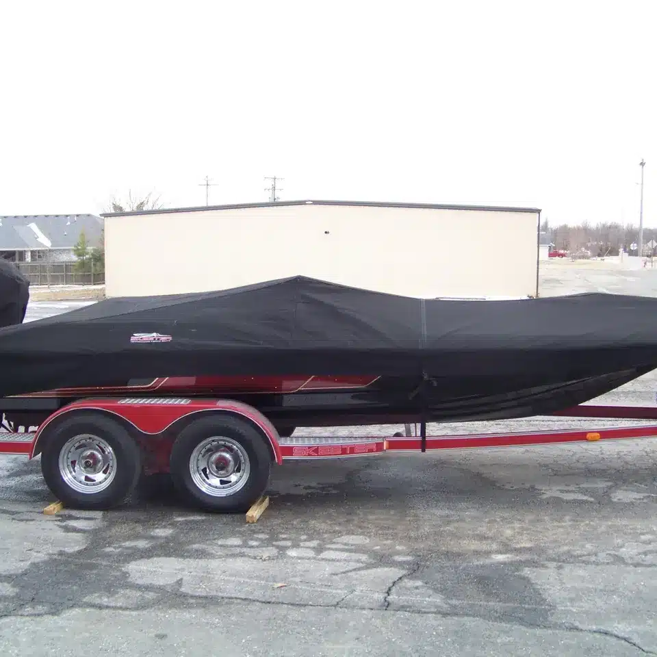 A side view of a black aurora canvas boat cover on a boat