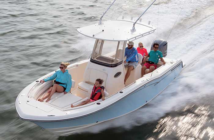 A top view of a whole family sitting inside a boat splashing water in the sea