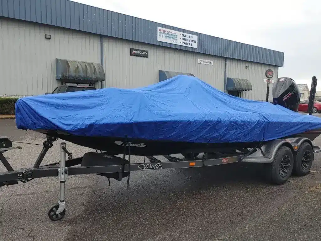 A view of a boat parked outdoors with a dark blue cover