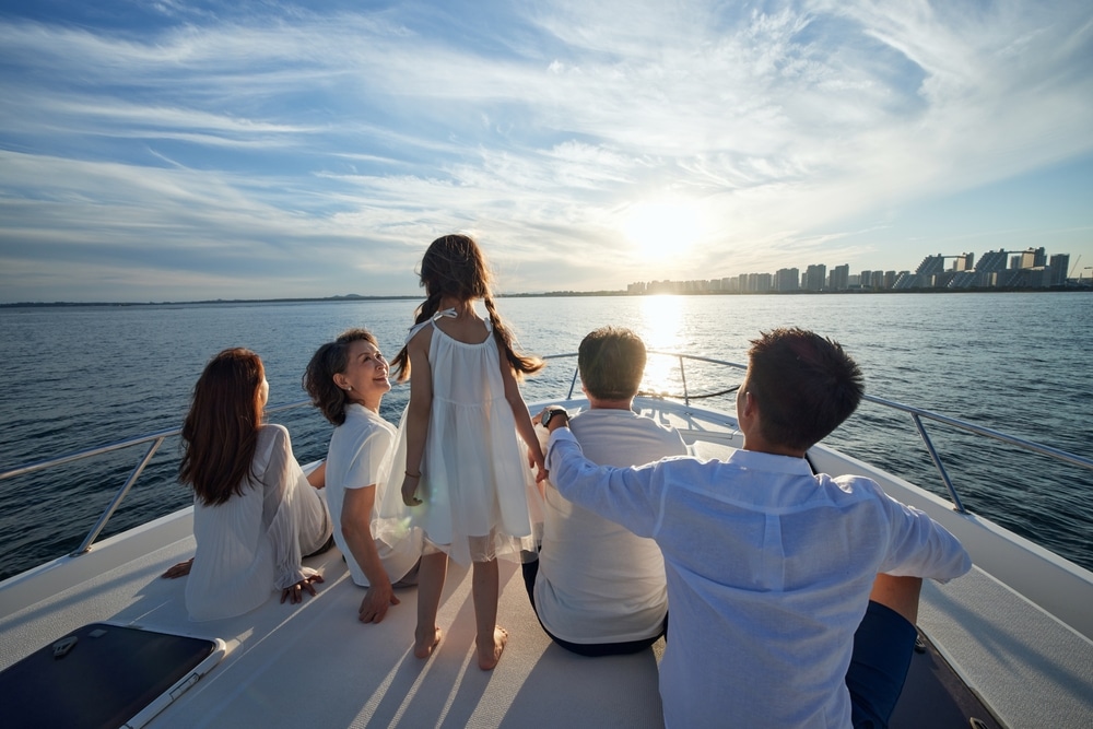 A view of a family sitting on a boat with a sea view