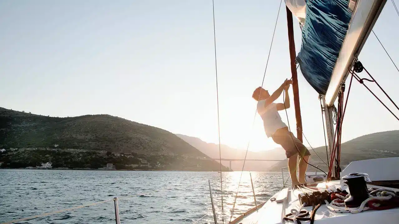 A view of a guy putting up sails on new boat