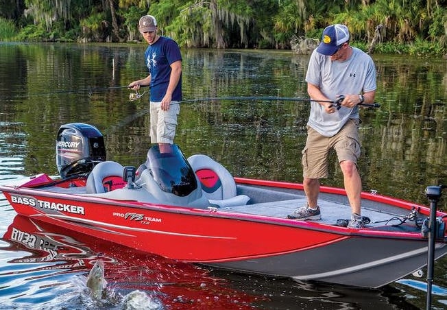 A view of two people standing and fishing on a bass boat