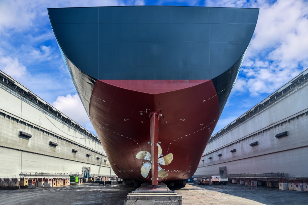 A view of a cargo ship's stern side on a dock