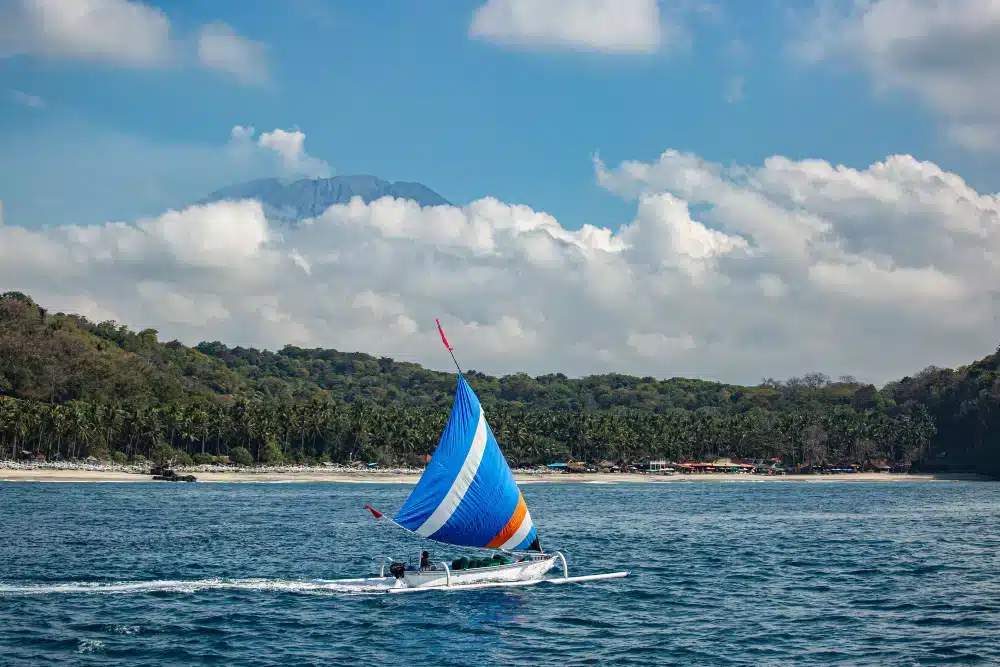 A view of a small sail boat floating on sea jpg