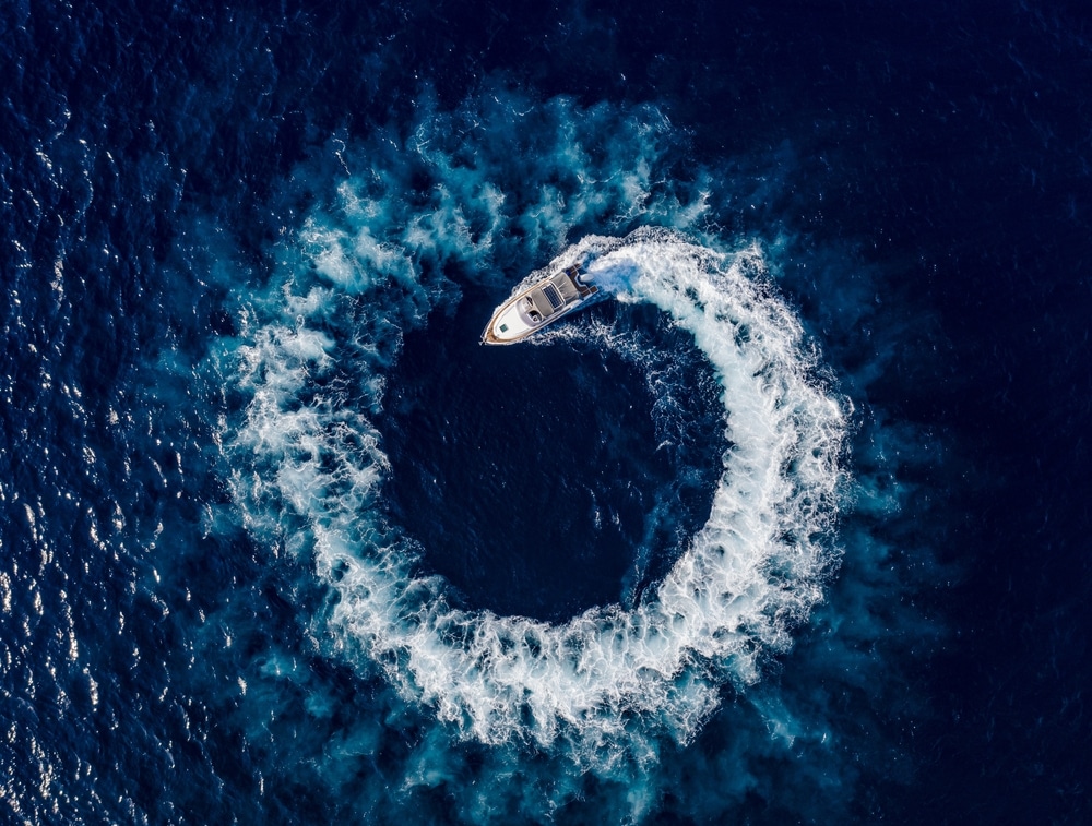 An aerial view of a boat making a loop in the sea