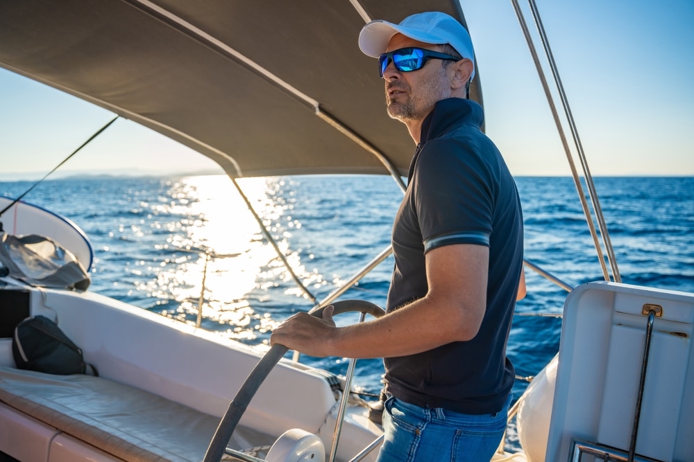 A view of a person standing on a boat wearing glasses