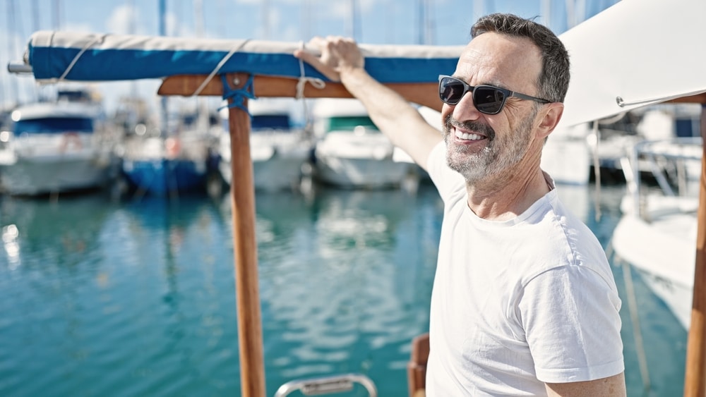 A view of a smiling man wearing glasses on a boat